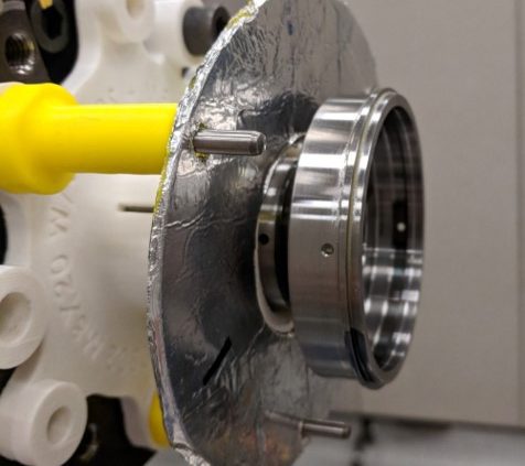 Closeup of a metal part with a silver shield.